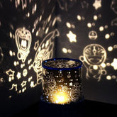 Colorful star projector lamp casting star and character patterns on walls, creating a magical night sky effect.
