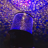 colorful star projector lamp creating a stunning starry night light display on the ceiling and walls.